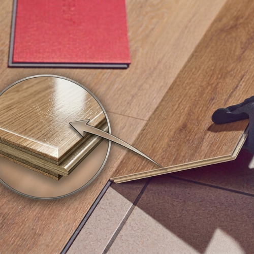 Persoon met handschoenen legt een PVC-vloerplank; close-up toont de opbouw van de plank met nadruk op de slijtlaag/toplaag.