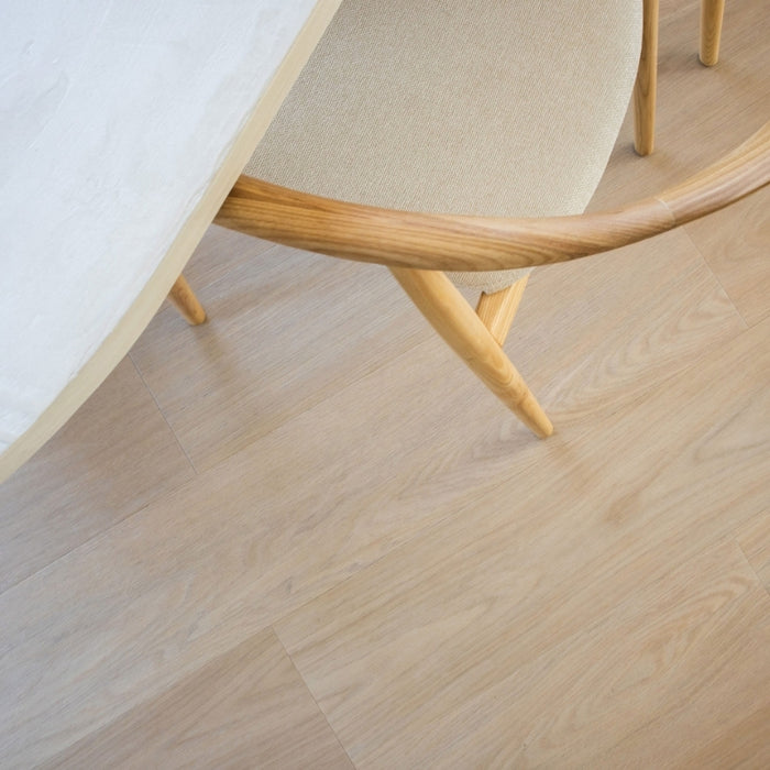 Detail van Vivafloors 7810 click pvc vloer onder een houten stoel en tafel.